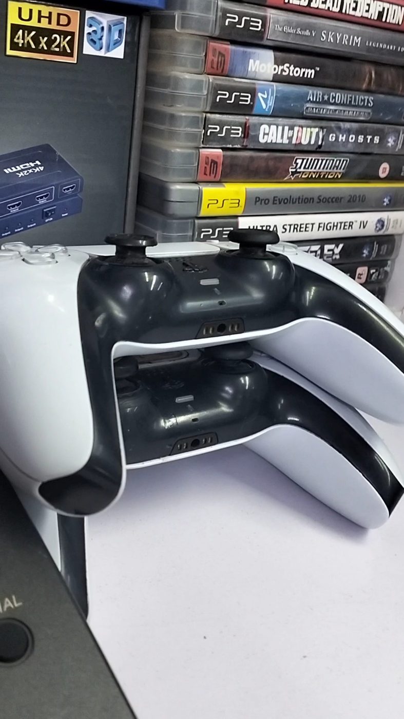 DualSense controllers in front of PS3 and PS4 games at Shangtao